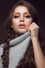 Beautiful young girl with gentle make-up in warm sweater and long straight hair. Beauty face.