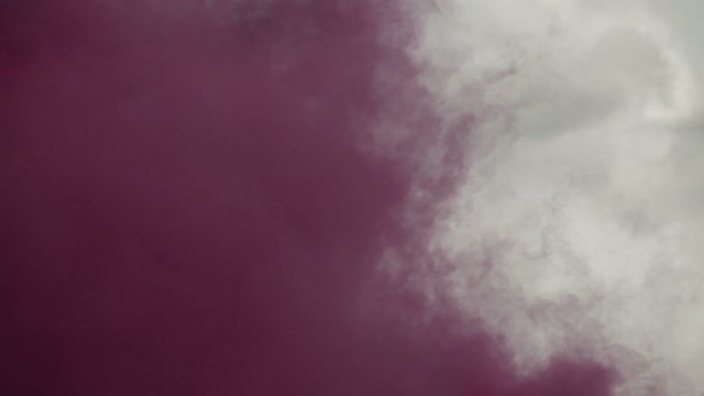 Purple cloud of smoke and training explosives on a hillside.