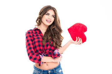 Beautiful happy woman with long curly hair holding red heart