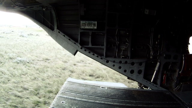 CH-47 Chinook helicopter as it lands, the ramp lowers, and soldiers move out.