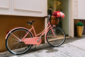 Fototapeta na wymiar Vintage bicycle with a decorative basket of flowers parking on s