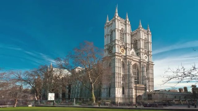 Time-lapse of Westminster Abbey under a blue sky in London.