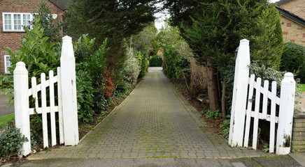 Driveway with white old wooden gate