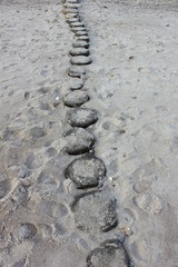Wooden posts on sandy beach
