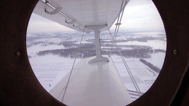 view from the airplane An-2. Through the window you can see the wing and winter. Snow. A frame similar to the Second World War. Or any other war, aviation battle