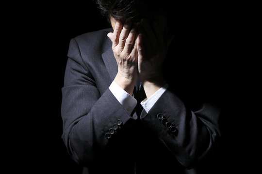 頭を抱える中年ビジネスマン