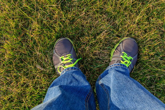 Men standing on the grass in jeans and sneakers