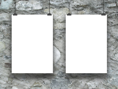 Two hanged paper sheets with clips on grey stone wall background