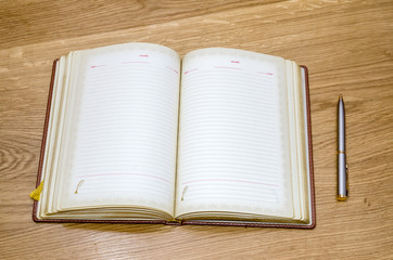 top view of old open book with fountain pen on wooden table