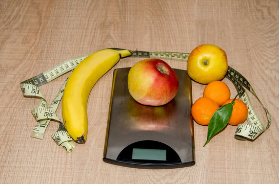 Concept of diet. Low-calorie fruit over measuring weight