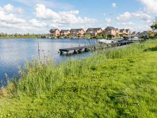 Fototapeta premium Waterside houses in green residential suburb, Almere in the province of Flevoland near Amsterdam