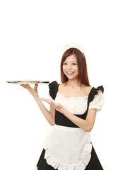 young Japanese woman wearing french maid costume presenting and showing something