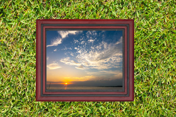 Wooden picture frame with view of sky and sea in evening time, o