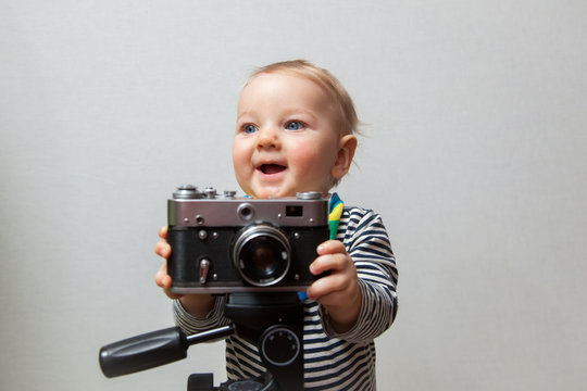 One year old boy with vintage old time photo camera