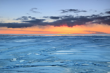 Naklejka na ściany i meble colorful sunset at the snowy Baltic sea shore