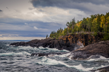 Lake Superior Coast, Gray sky and stormy seas crash on the cliffs of the black rocks along the...