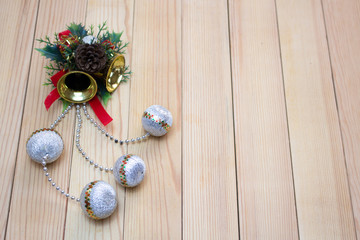 Christmas souvenir  with yellow bells and white balls on a wooden board