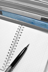 Black and white aged books with notebook, pen and blue book.