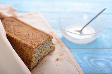 cake with poppy seeds wrapped in a napkin and glass cup with cre