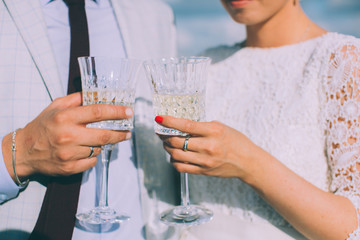 Young couple standing on the roof of the newly-married couple with glasses of champagne in their hands