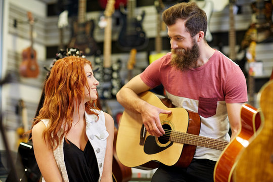 couple of musicians with guitar at music store