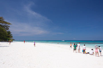 Fototapeta na wymiar Tourists on white sand beach