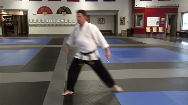 Man using sais in a karate studio.