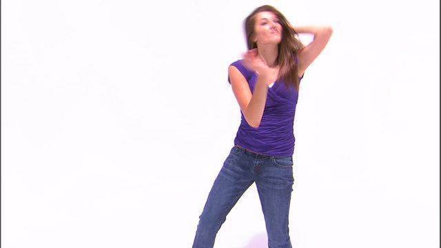 Shot of a girl dancing in a purple shirt and jeans.