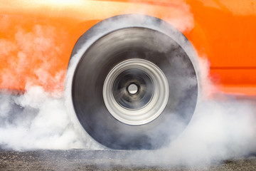 race car burns rubber off its tires in preparation for the race
