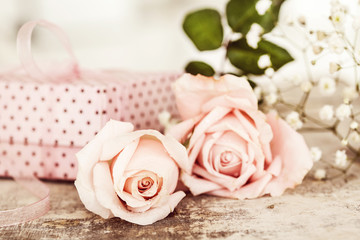 Two pink flowers with gift box