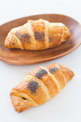 Fresh and tasty croissant on white wood table