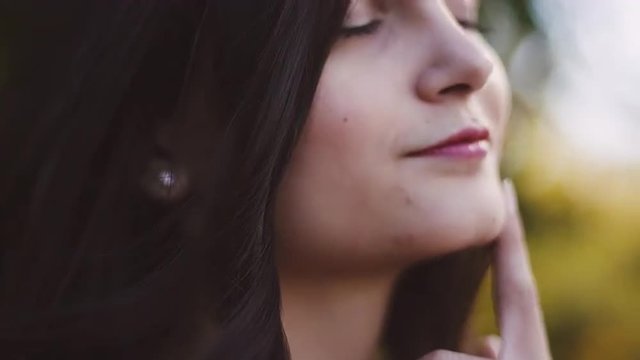 Close up of a beautiful girl outdoors, slow motion with bokeh