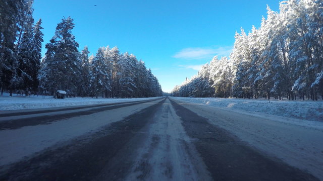 Movement of the car in the winter. A driving on snow road, to a clear sunny day. 
