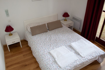 Double Bed In The Bedroom With Desk Lamp Near It