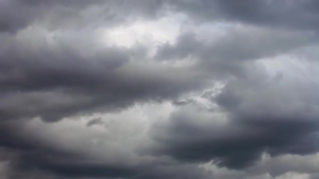 Amazing dramatic leaden view of the leaving low dark clouds without any sunshine. Gray leaden sky scape, making dismal mood. Fast motion with time lapse effect. Curling puffy wreathing background.
