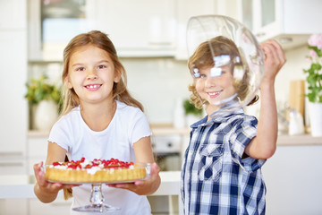Kinder präsentieren Obstkuchen in Küche