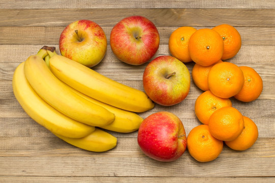 group of apple banana and mandarin fruits on wood