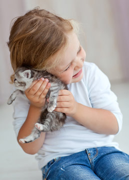 Little kid are playing with a kitten 