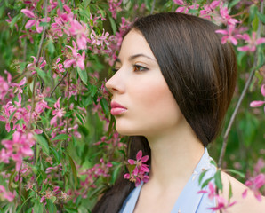 Fototapeta premium Portrait of a woman near flowering tree