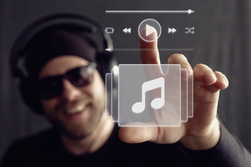 Man wearing headphones clicks the play button