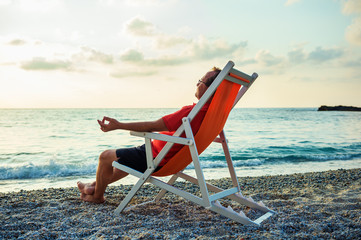 Fototapeta na wymiar Man relaxing on beach at sunset