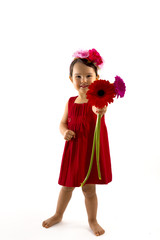 little girl in red dress giving a gerbera bouquet