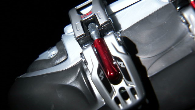 Close up of ski boot buckle being latched.