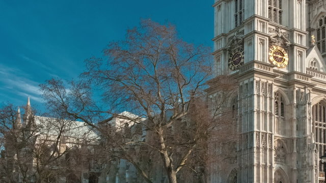 Panning time-lapse of Westminster Abbey under a blue sky in London.