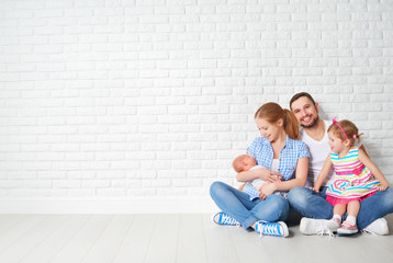 happy family father mother and children at empty wall