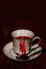 A vampire's tea cup with blood running down the side; textured image - 100145811