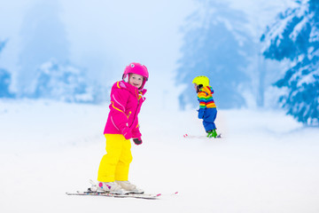 Two children skiing in snowy mountains