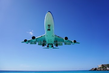 A jumbo jet airplane flying low over water