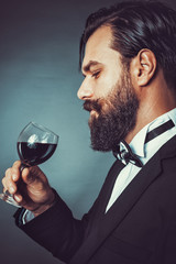 Portrait of a successful young man with retro look holding a gla