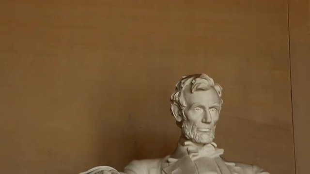 Tilt shot of dedication on Lincoln Memorial wall and Abraham Lincoln statue in Washington DC